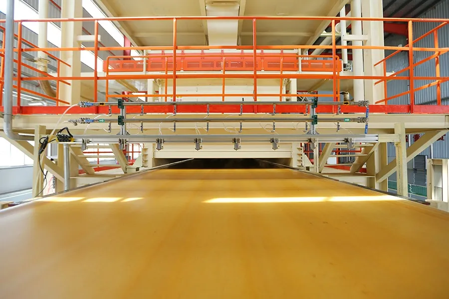 Board exiting a continuous press, low angle down the conveyor